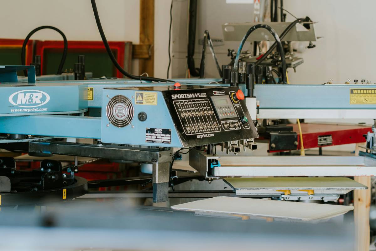 Technician aligning custom screen printing design with precision registration marks